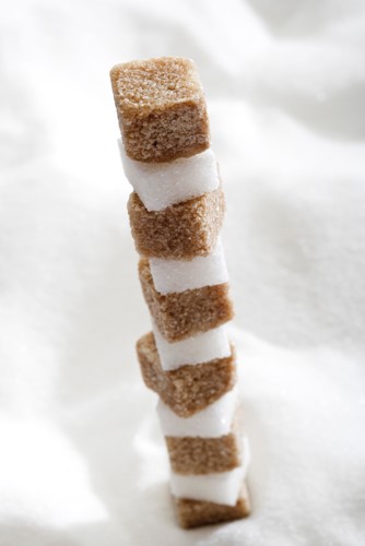 Brown and white sugar, sugar cubes stacked on a pile of sugar