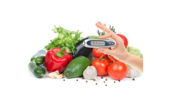 Someone holding a blood glucose monitor in front of vegetables